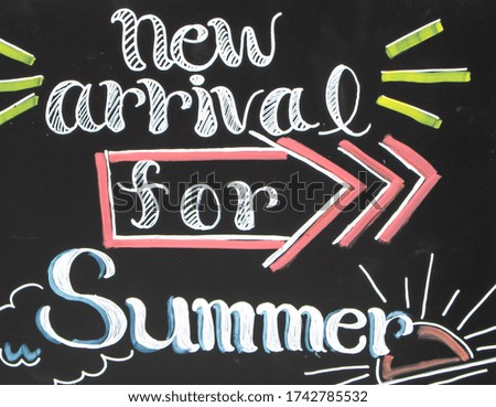Blackboard with "new arrival for summer" written on it in decorative letters