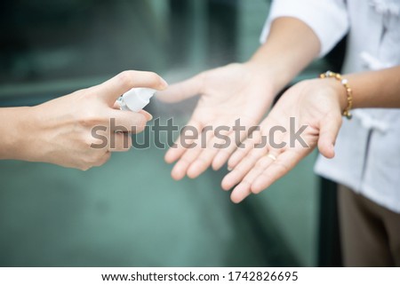people using alcohol hand spray to kill germs on palm skin; concept of alcohol spray for hand disinfection, touching surface disinfectant, hand sanitizer for coronavirus covid-19, personal health care Royalty-Free Stock Photo #1742826695