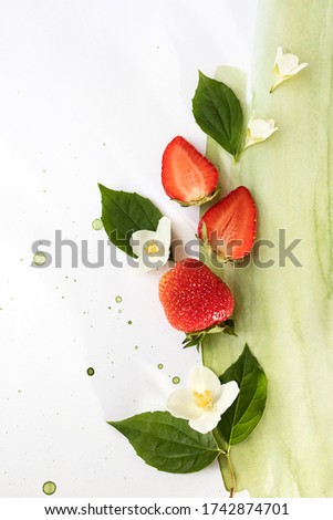 The creative composition is made of bright strawberries on a two-color watercolor background. Flat lay. The concept of food. Copy space.