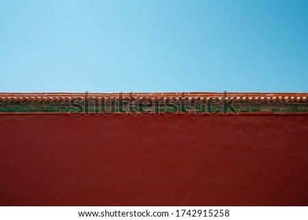 Chinese traditional red wall with blue sky. Minimal background.