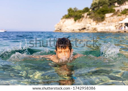 Little kid having fun into the sea