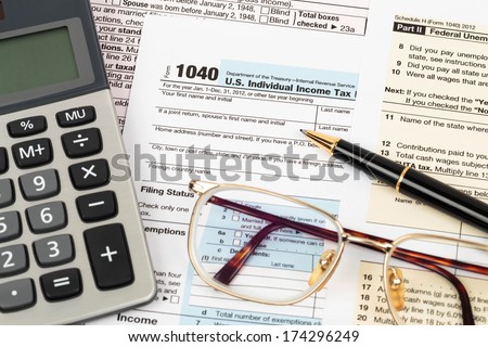Tax form with pen, calculator, and glasses taxation concept