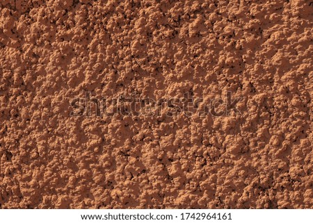 Wall with brown plaster texture background. Coffee color backdrop. Bronze Ochre Orange shades surface. Textured building photo for creativity, adding text sign for advertising. Architectural details.