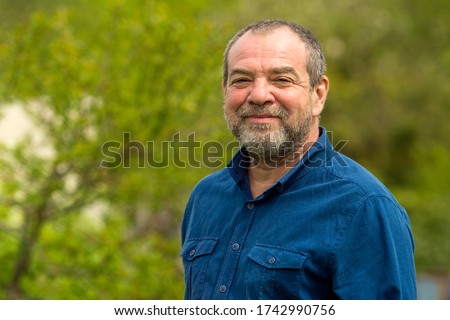 Smiling friendly unshaven adult man outdoors portrait
