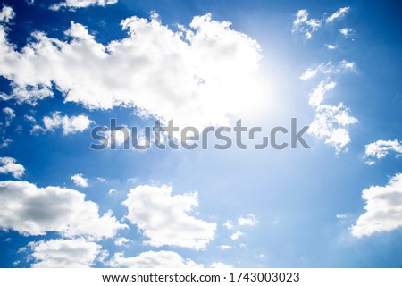 white clouds and sun in the blue sky