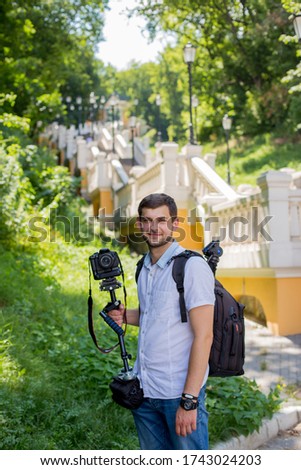a man with beard camera and a monopod