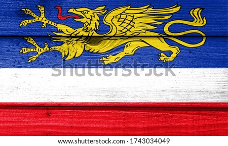 Rostock flag painted on old wood plank background. Brushed natural light knotted wooden board texture. Wooden texture background flag of Rostock