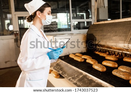 Bread. Bread production line. Girl in uniform. Sanitary check. Bakery Royalty-Free Stock Photo #1743037523