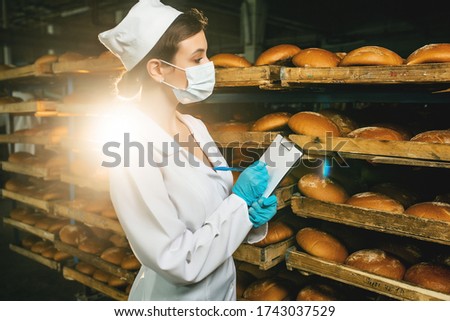 Bread. Bread production line. Girl in uniform. Sanitary check. Bakery Royalty-Free Stock Photo #1743037529