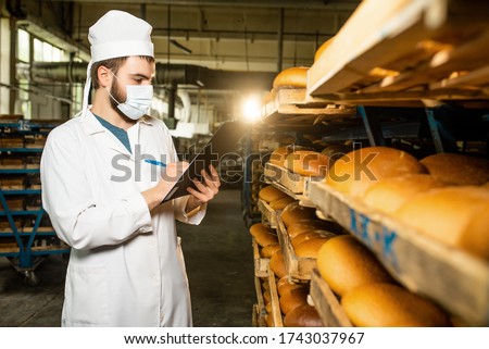 Bread. Bread production line. A man in uniform. Sanitary check. bakery Royalty-Free Stock Photo #1743037967
