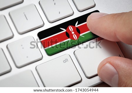Online International Business concept: Computer key with the Kenya on it. Male hand pressing computer key with Kenya flag.
