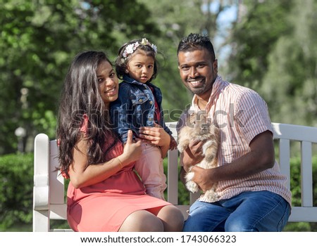  happy asian family with rabbit in city park