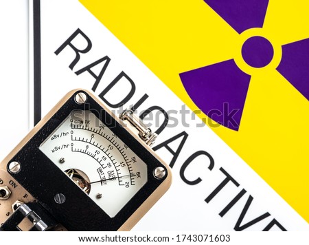 Hand-held radiation survey instrument detecting at the radioactive material symbol on label Royalty-Free Stock Photo #1743071603
