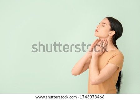 Young woman with thyroid gland problem on color background Royalty-Free Stock Photo #1743073466