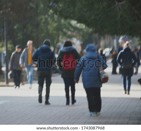 Blurred background. Silhouettes of people in the street of the city. City life.