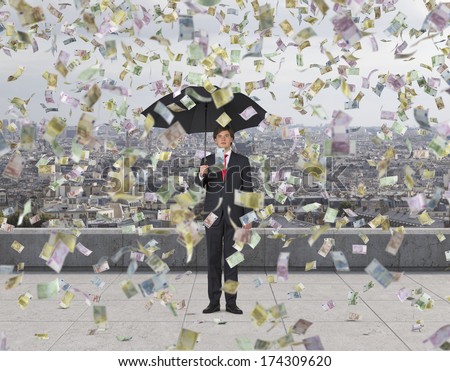 Businessman with an umbrella under the euro rain, roof terrace(all euro nominal)