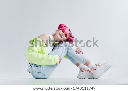 girl in jeans and a green sweater sits on the floor pink hair teenager makeup