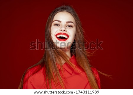 Happy woman laughing at the camera on a red background