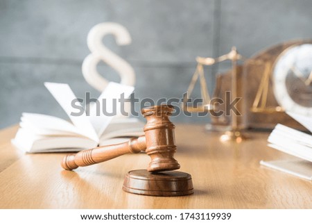 Law and Justice concept. Gavel of the judge, books, scales of justice. Gray stone background.