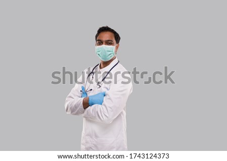 Doctor Wearing Medical Mask and Gloves Isolated. Indian Man Doctor Hands Crossed Medical Concept. Side View Royalty-Free Stock Photo #1743124373
