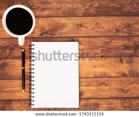Flat lay, Office table vintage wooden desk, Bright Creative workspace with the pen, notebook, and cup of black coffee  with the sunlight, Top view with copy space