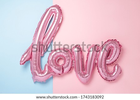 Pink balloons in the form of word Love on pink and blue background. Romantic mood - Image