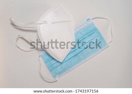 
Different types of face masks for protection against COVID-19, FPP2, and surgical masks, in a top view with white background.  Royalty-Free Stock Photo #1743197156