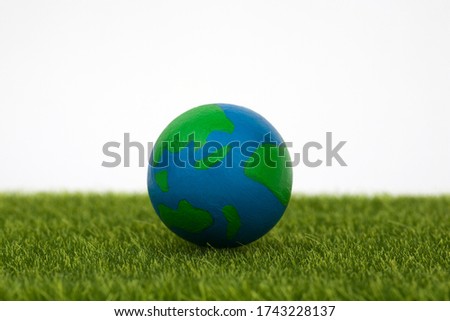 globe on green grass with white background