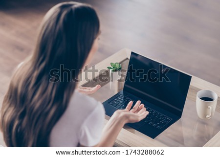 Rear behind view photo of student lady resume interview employment concept notebook online video call raise arms telling personal qualities quarantine time stay home living room indoors