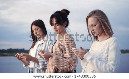 Friendship, technology and internet concept - three young women