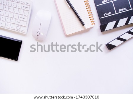 Flat lay, Movie clapper and notebook on white background with blank space for text.