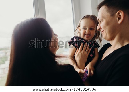 little cheerful girl plays with mom and dad