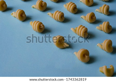 Creative background with insalatonde pasta on a light blue background. Geometric shapes and lines from the Ingredients of Traditional Mediterranean Cuisine. Gastronomy. Copy space.