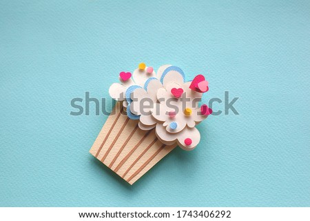 Paper cutting cupcake on blue background. Handmade art work. Colorful sprinkles, dot and star, for your birthday card design. 