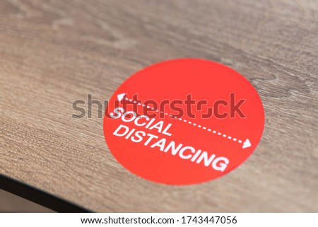 Social Distance word sticker on the table in restaurant.Social Distancing Instruction against the Spread.New normal Reopen Mall, School.Social distancing in the workplace during coronavirus COVID-19.