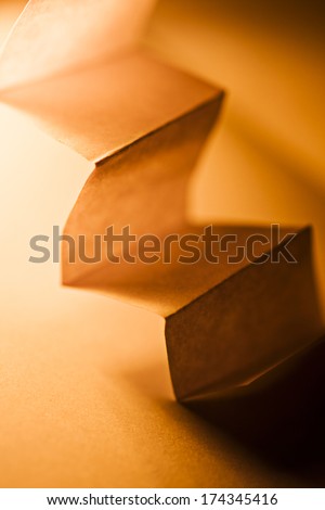 Macro, abstract, background picture of a  orange zig-zag paper on paper background 