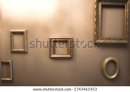 Empty golden luxury frames on vintage design wall, space for text. antique luxe interior background