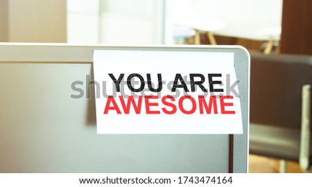 reminder white sticker on the monitor in the office with text YOU ARE AWESOME