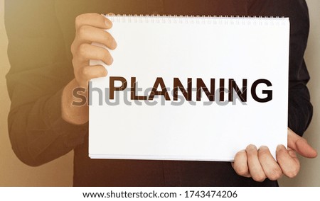 Man holding brochure with PLANNING text on grey background. Mock up for design