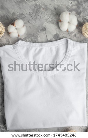 Layout with a white T-shirt Flat lay with cotton flowers, soft and light photo. For placing fonts, logos