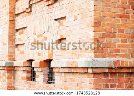 Fragment of a building made of old red brick with Windows