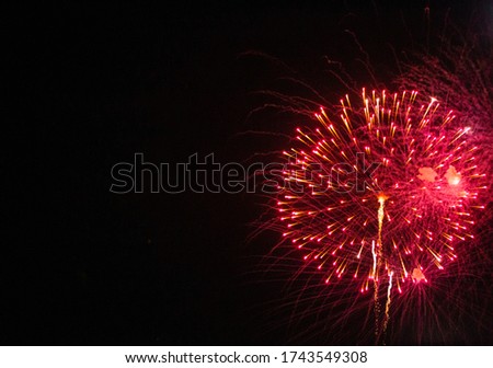 colorful red and yellow fireworks on an evening night background with space on a side for celebration concept