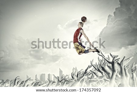 Young man basketball player with ball in hands jumping high