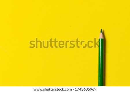 Top view green pencil on yellow background with copy space. Vacation homework concept. summer crafts concept. marketing concept.