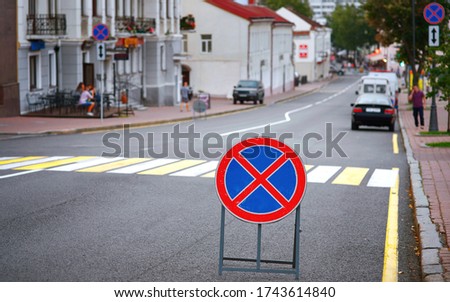 No parking, road sign is in front of pedestrian crossing. No parking and stopping on the road - road sign, traffic rules. Lack of parking spaces in the city center