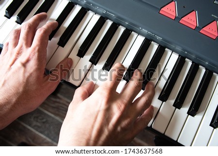 Male playing the piano keyboard. Top view hands close up.