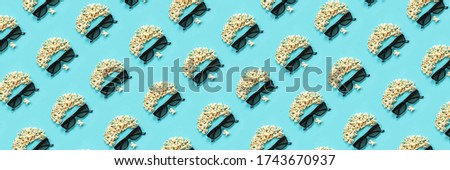 Pattern made with abstract image of viewer, 3D glasses and popcorn on blue background. Creative concept cinema movie and entertainment Flat lay Top view.