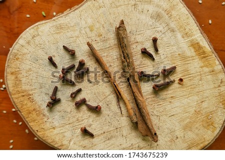 cloves and cinnamon in the wooden plate and sesame seeds