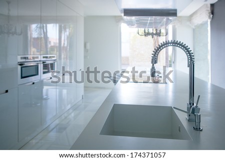 Modern white kitchen perspective with integrated bench sink and spring faucet