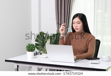 Young asian female in student study at home. She using laptop and learning online.